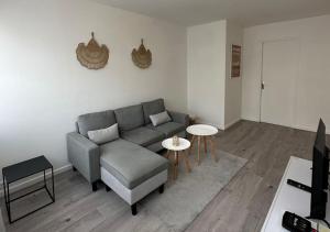 a living room with a couch and a table at Le charme Chalonnais in Chalon-sur-Saône