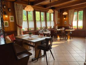 ein Esszimmer mit Tischen, Stühlen und Fenstern in der Unterkunft Gasthaus Breitenbach in Bad Brückenau