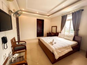 1 dormitorio con 1 cama, TV y ventana en Seika Hotel by The Moment en Vung Tau