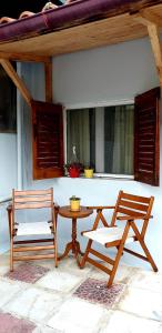 patio z 2 krzesłami, stołem i ławką w obiekcie Elizas house w mieście Nea Makri