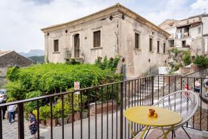 un tavolo giallo e sedie sul balcone di Mirador Savoca a Savoca