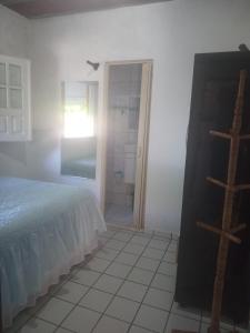 a bedroom with a bed and a bathroom with a window at Condomínio Amanda Travassos in Jaguaribe