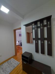 a living room with a black shelf on the wall at Apartmani Bojković in Vrnjačka Banja +15 photos