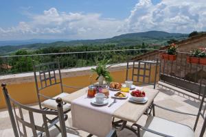 einen Tisch mit Frühstückszutaten auf dem Balkon in der Unterkunft Delcorto Suites in Montepulciano