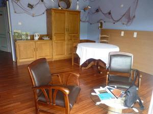 sala de estar con mesa, 2 sillas, mesa y mesa en La Suite du Pêcheur, balnéo et terrasse privative. Entre terre et mer, en Tréméoc