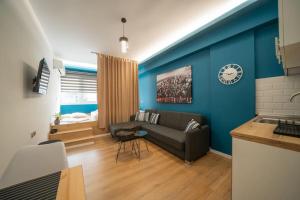 a living room with a couch and a clock on the wall at Kozani Residence 1 in Kozani