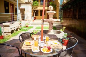 una mesa con platos de comida y una fuente en Hotel Santa Rosa, en Arequipa