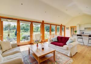 a living room with two couches and a table at Akenfield Cottage, Letheringham in Kettleburgh