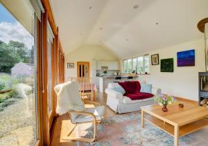 a living room with a couch and a table at Akenfield Cottage, Letheringham in Kettleburgh