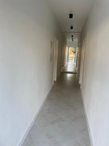 an empty hallway with white walls and tile floors at Apartamenty Lipowy Zakątek in Iława