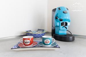 two cups on a tray next to a coffee maker at Carpe Diem House in Bacoli