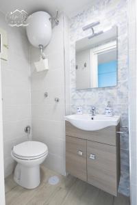 uma casa de banho com um WC, um lavatório e um espelho. em Carpe Diem House em Bacoli