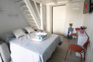 um pequeno quarto com uma cama e uma escada em Carpe Diem House em Bacoli
