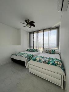 1 dormitorio con 2 camas y ventilador de techo en Condominio Zazue, en Santa Marta
