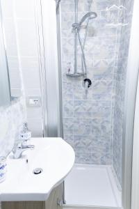 uma casa de banho com um lavatório branco e um chuveiro em Carpe Diem House em Bacoli