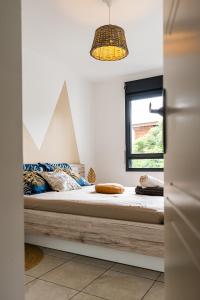 a bedroom with a bed and a window at Le Cocon de l'Etang in Bout de lʼÉtang