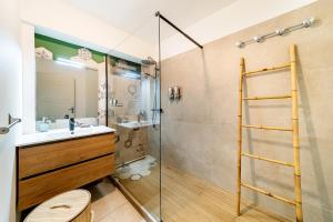 a bathroom with a glass shower and a sink at Le Cocon de l'Etang in Bout de lʼÉtang