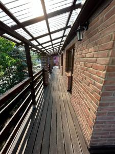 a wooden porch with awning on a brick building at Pensjonat pod Dębami in Pobierowo