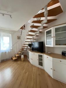 una sala de estar con armarios blancos y una escalera en Apartment Sonata, en Kamnik