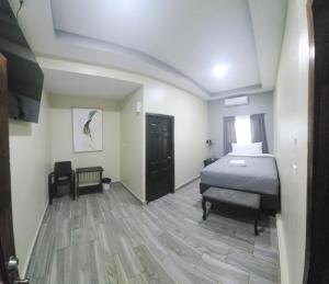 San Luis的住宿－Mi Tierra Hotel y Restaurante，一间卧室配有一张床和一把椅子
