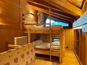 a bedroom with bunk beds in a wooden cabin at MaisonGorret in Valtournenche