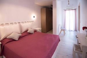 a bedroom with a large bed with a red blanket at Meltemi 1 in Nea Cryssi Akti