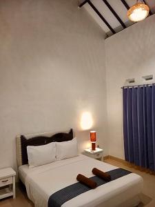 a bedroom with a large bed with blue curtains at Singon LOMBOK homestay in Selong Belanak
