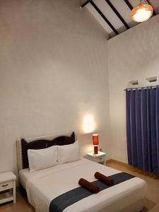 sypialnia z dużym łóżkiem z niebieskimi zasłonami w obiekcie Singon LOMBOK Homestay and Surf w mieście Selong Belanak