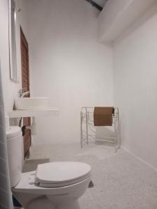 biała łazienka z toaletą i umywalką w obiekcie Singon LOMBOK Homestay and Surf w mieście Selong Belanak