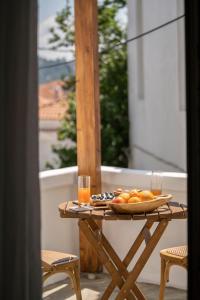 a table with a plate of fruit and two glasses at Raphael Skiathos Living-Olga in Skiathos Town