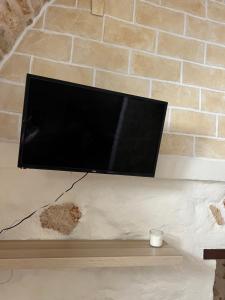 カロヴィーニョにあるCasa Carolinaの煉瓦壁に掛けられた薄型テレビ