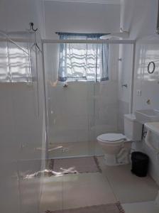 ein Bad mit einer Dusche, einem WC und einem Waschbecken in der Unterkunft Recanto Maria Flor in Guarujá