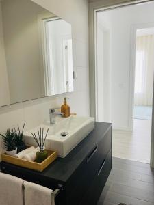 a bathroom with a sink and a mirror at Rancho Tá-Mar Apartment Nazaré Beach in Nazaré