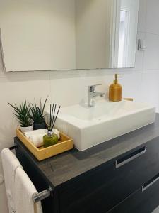 a bathroom with a white sink and a mirror at Rancho Tá-Mar Apartment Nazaré Beach in Nazaré