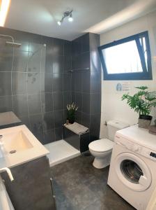 a bathroom with a toilet and a washing machine at Apartamentos Albatros in Puerto del Carmen