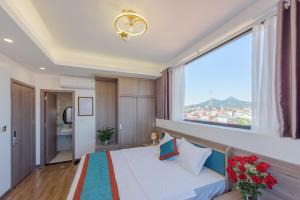 sypialnia z łóżkiem i dużym oknem w obiekcie LONG VŨ HOTEL w mieście Lạng Sơn