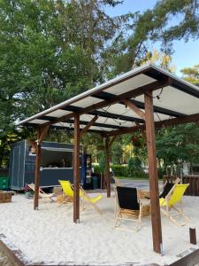 a group of chairs under a pavilion on the beach at Pensjonat pod Dębami in Pobierowo