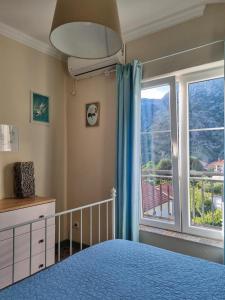a bedroom with a bed and a large window at Apartment Mint&Rose in Risan