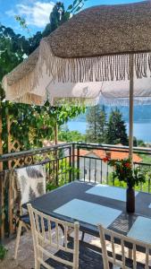 a table and chairs on a patio with an umbrella at Apartment Mint&Rose in Risan