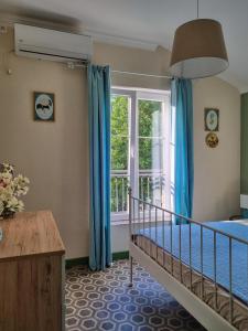 a bedroom with a bed and a window with blue drapes at Apartment Mint&Rose in Risan