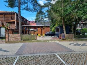 a brick road in front of a building with a parking lot at Pensjonat pod Dębami in Pobierowo