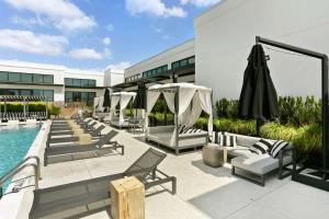 亚特兰大Luxury Apt in West Midtown的一座带躺椅和遮阳伞的游泳池位于大楼旁