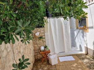 a shower with a white shower curtain and trees at Villa SeaBreeze in Rogoznica