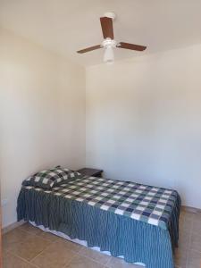 Cette chambre comprend un lit et un ventilateur de plafond. dans l'établissement Chácara Rancho Fundo, à Águas de Lindóia