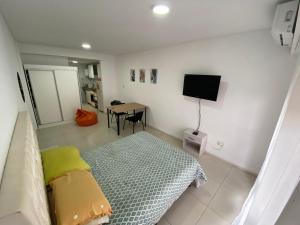 Habitación con cama, mesa y TV. en Depto zona centro muy comodo. en Rosario