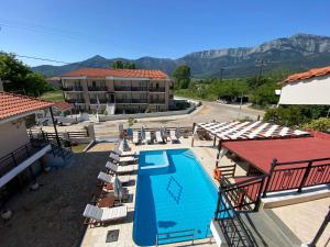 a swimming pool with lounge chairs and a hotel at Porto Marina in Chrysi Ammoudia