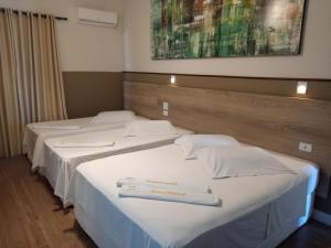 two beds in a hotel room with towels on them at Smart Hotel in Registro