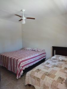 - une chambre avec 2 lits et un ventilateur de plafond dans l'établissement Chácara Rancho Fundo, à Águas de Lindóia