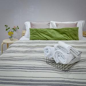 - un lit avec des serviettes blanches dans l'établissement Astoria Apartments, à Almaty