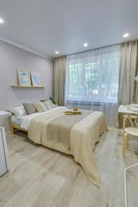 - une chambre avec un grand lit et une grande fenêtre dans l'établissement Astoria Apartments, à Almaty